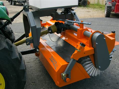 Balayeuse à gazon tractée fixée à un tracteur de jardin