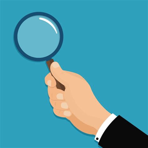 une main tenant une loupe au-dessus d'un petit trou dans la pelouse