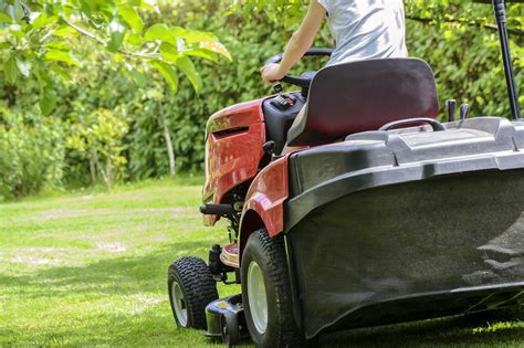 Tracteur tondeuse sur un vaste terrain paysagé