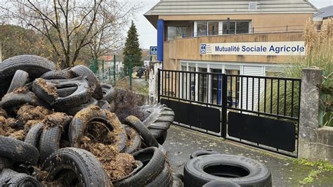 Dépôt de fumier et de pneus devant un bâtiment