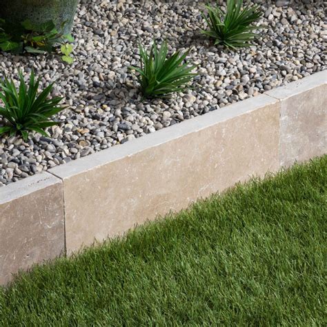 Bordure en pierre naturelle beige longeant une allée