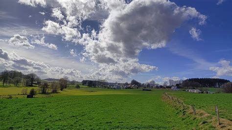 Champs de culture sous un ciel changeant symbolisant les défis agricoles