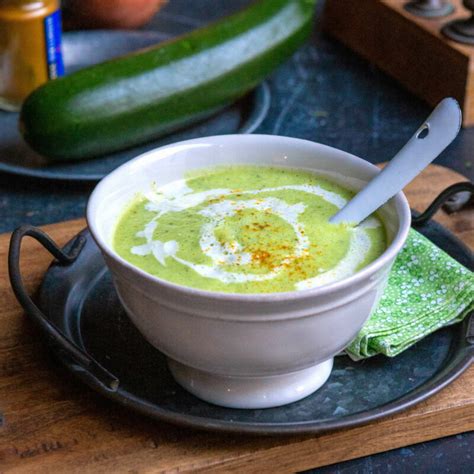 Bol de velouté de courgettes et endives garni de crème fraîche et d'herbes fraîches