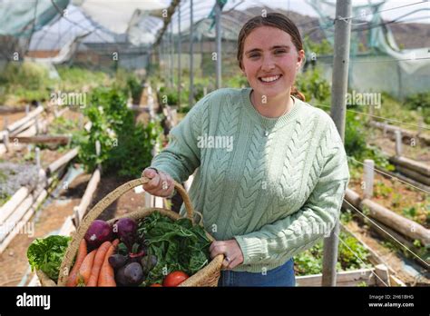 Portrait d'une agricultrice souriante dans un champ de légumes