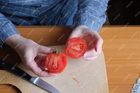 Gros plan sur une main récoltant une tomate mûre dans un champ