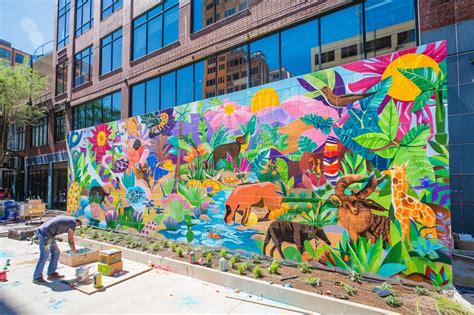 Une fresque murale complexe mélangeant tags et éléments artistiques dans une rue de Bruxelles