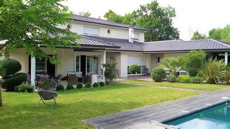 Image d'une maison moderne avec un jardin bien entretenu et des outils BLACK+DECKER en arrière-plan