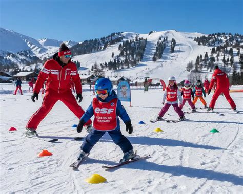 Enfants apprenant à skier avec un moniteur ESF