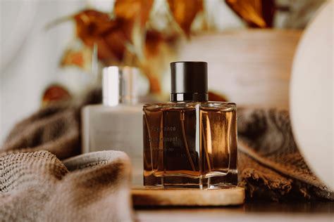 Une vue artistique d'un flacon Diptyque posé sur une table en bois clair, entouré de feuilles de figuier