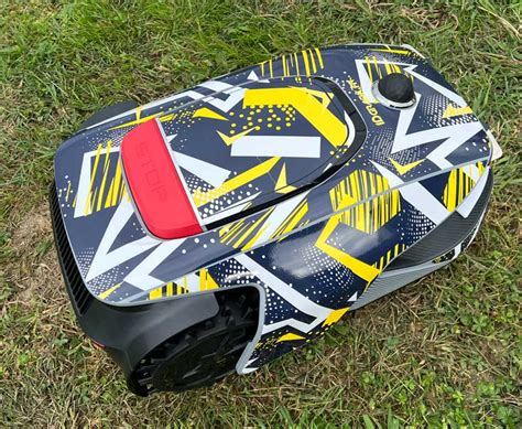 Robot tondeuse personnalisé avec des motifs colorés dans un jardin