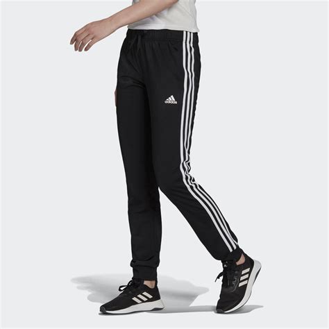 Un homme portant un pantalon de sport Adidas clematite en train de s'entraîner à l'extérieur.