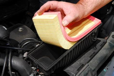 Schéma technique montrant l'emplacement du filtre à air et du cache de protection sur un moteur thermique de débroussailleuse