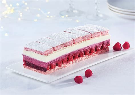 Bûche de Noël framboise et chocolat blanc sur un plat de service élégant