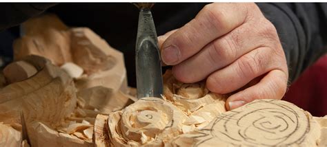 Un sculpteur ornemaniste travaillant sur une pièce de bois