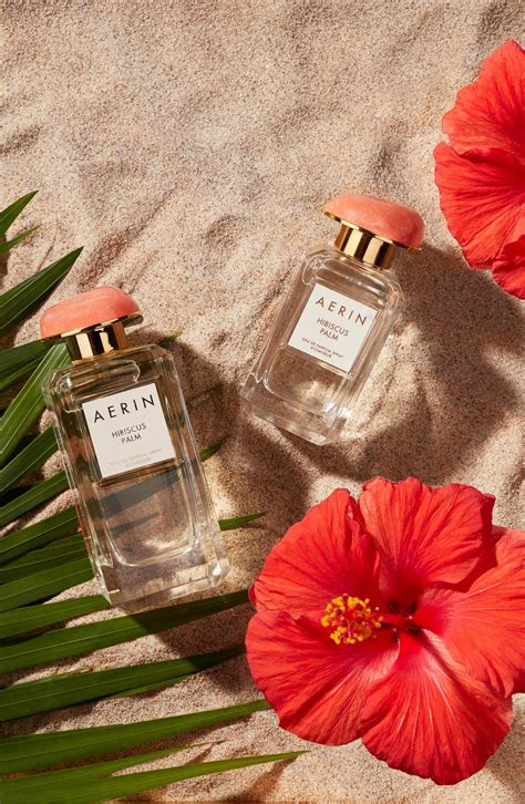Bouteille de parfum Hibiscus Palm d'Aerin Lauder sur une plage tropicale
