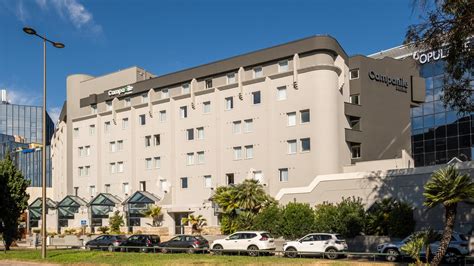Façade de l'hôtel Campanile PRIME Nice Aéroport avec la Promenade des Anglais en arrière-plan