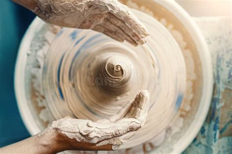 Mains sculptant de l'argile sur un tour de potier