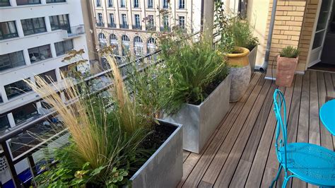 Jardinières rectangulaires alignées sur un balcon, créant une séparation naturelle
