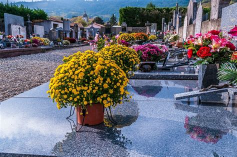 Personnes se recueillant devant une tombe fleurie