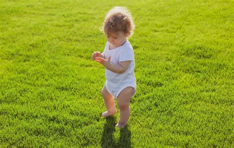 Bébé jouant dans l'herbe pieds nus