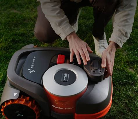 Technicien réalisant la maintenance d'un robot tondeuse
