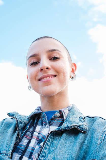 une femme avec les cheveux rasés souriant