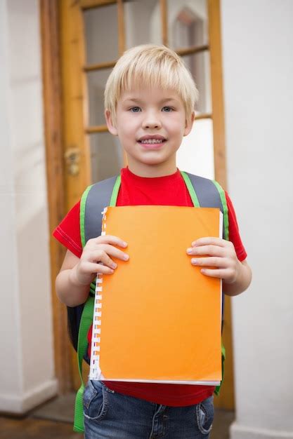 Enfant souriant jardinant avec un cahier