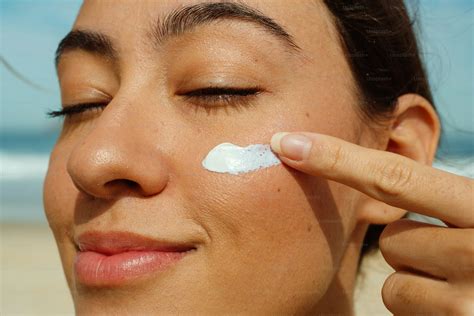 femme appliquant de la crème sur son visage