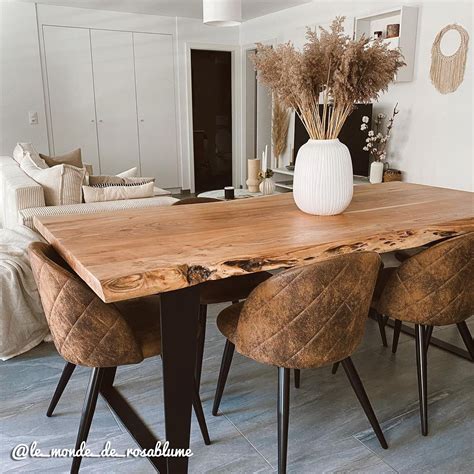 Table rectangulaire rustique en bois brut avec plateau en lattes et grillage métallique sur une terrasse en bois gris