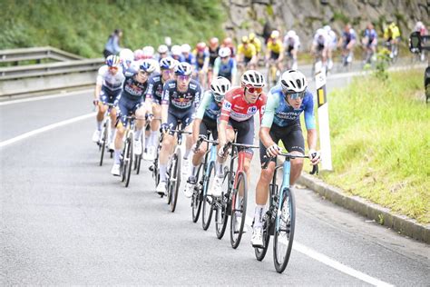 Photographie du peloton en éventail, avec des coureurs en difficulté sur la bordure de la route