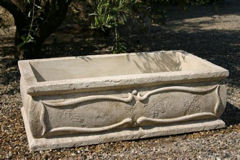 Jardinière de vendange en pierre reconstituée dans un jardin fleuri