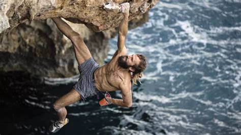 Grimpeur pratiquant le psicobloc au-dessus des eaux turquoise