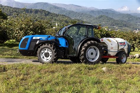 Tracteur fruitier compact opérant dans un verger serré