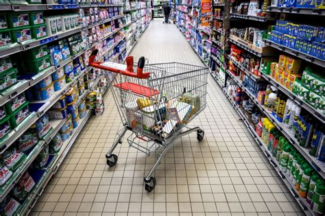 une main tenant des bonbons près d'une caisse de supermarché