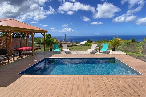 Vue d'une piscine privée avec carbet et végétation tropicale