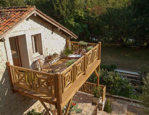 une rangée de caisses en bois transformées en jardinières sur un balcon ensoleillé