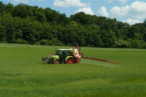 Champ normand avec un agriculteur épandant de l'engrais