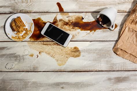 Tasse de café renversée sur une table, créant une tache sombre et une vapeur légère.