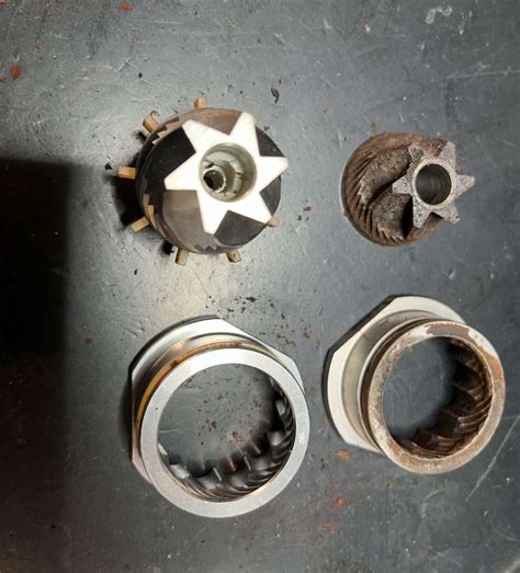 Vue rapprochée des meules d'un broyeur DeLonghi et nettoyage au pinceau