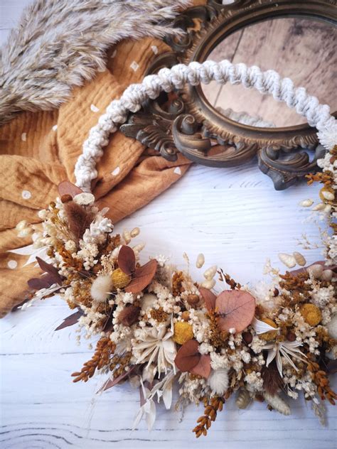 une couronne de fleurs séchées artisanale posée sur une table en bois clair