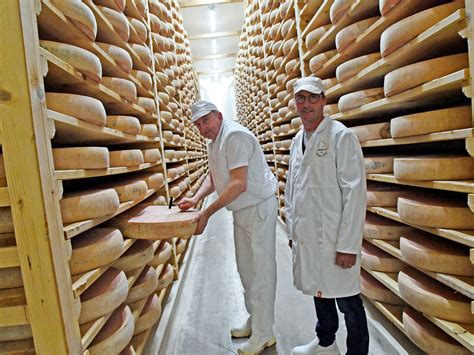 Intérieur d'une fruitière traditionnelle avec fromager au travail