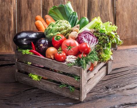 Maraîcher bio emballant des légumes dans des cagettes en bois