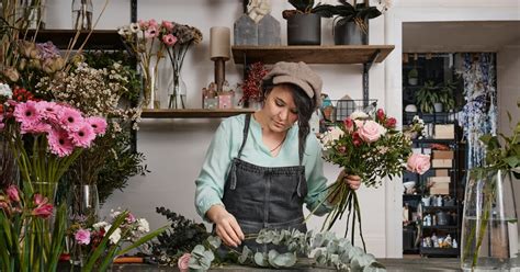 Un artisan fleuriste arrangeant des fleurs dans un atelier
