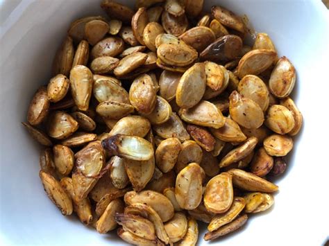 Image d'un bol de graines de courge grillées, salées ou incorporées dans un granola