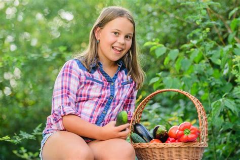 Enfant souriant en cueillant une tomate
