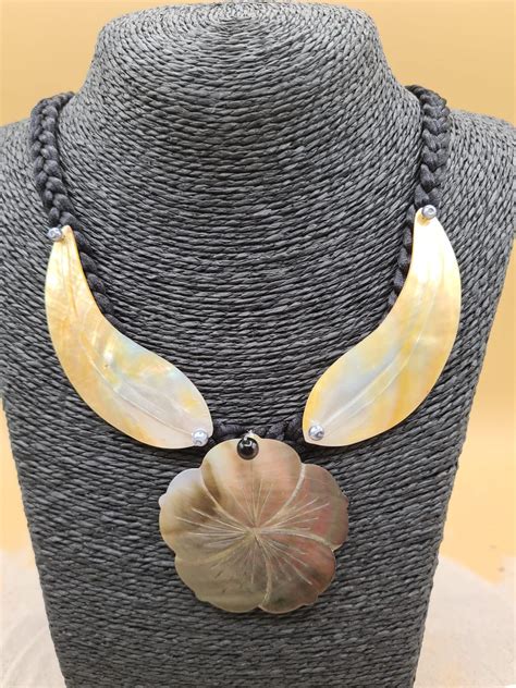 Collier en nacre gravé d'un motif hibiscus polynésien