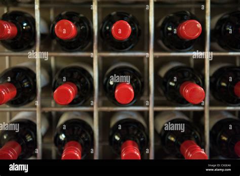 Bouteilles de vin rouge alignées dans une cave