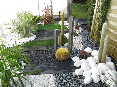 Jardin zen avec gravier blanc, plantes succulentes et piquets en bois