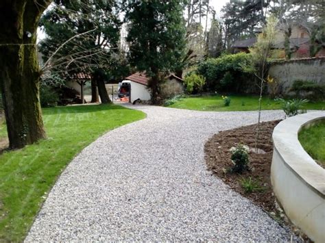 Allée de jardin en gravier blanc avec des bordures en bois