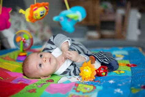 bébé jouant sur un tapis d'éveil coloré